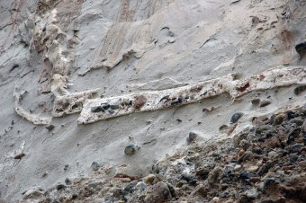 While it is difficult to quantitatively assign a paleo-magnitude to this seismic event(s), this photos shows cobbles entrained in the clastic dyke that is superimposed on the megablock complex, as well as in the bottom of the fluidized, injected material (grey), which suggests very intense seismic activity.