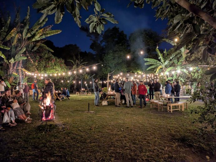 Farewell party at La Azotea coffee plantation - people around tables and campfires.